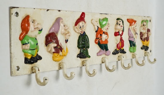 A 'Seven dwarfs' painted cast iron coat rack, 58cm wide. Condition - fair, some chipping